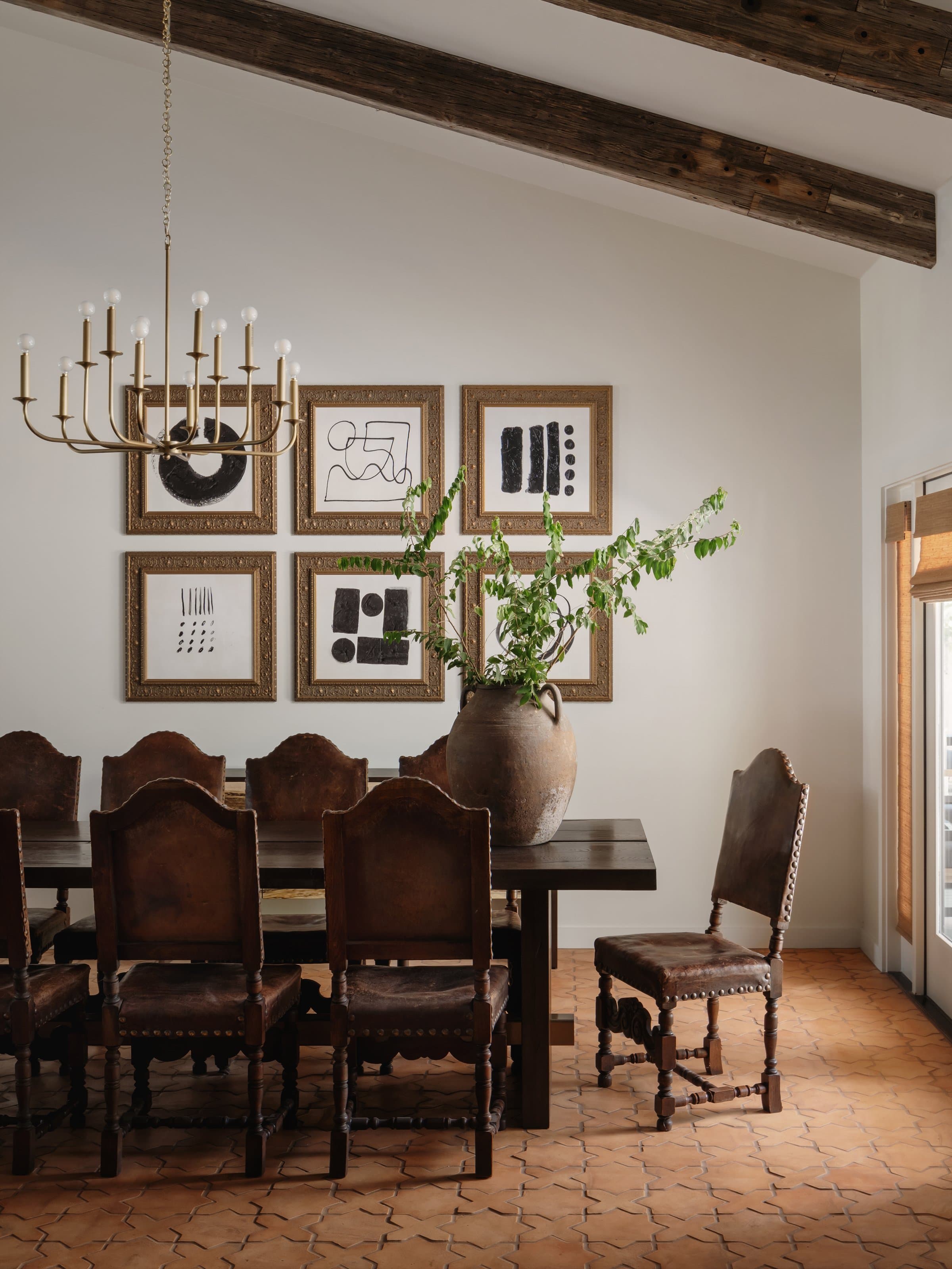 Dining room with brass chandelier and terracotta tile at Casa Alegre Fredericksburg Texas