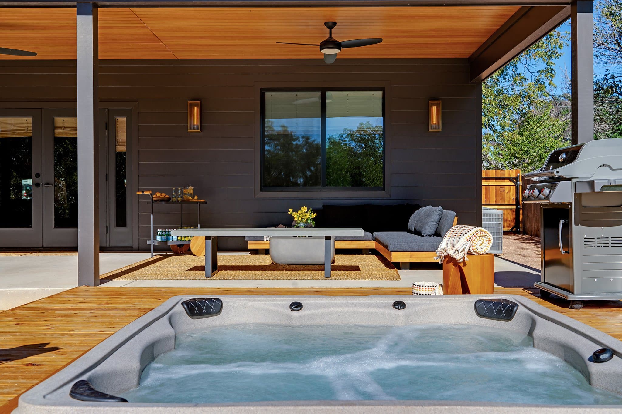 Outdoor living area with hot tub deck and gas grill at Casa Alegre Fredericksburg Texas